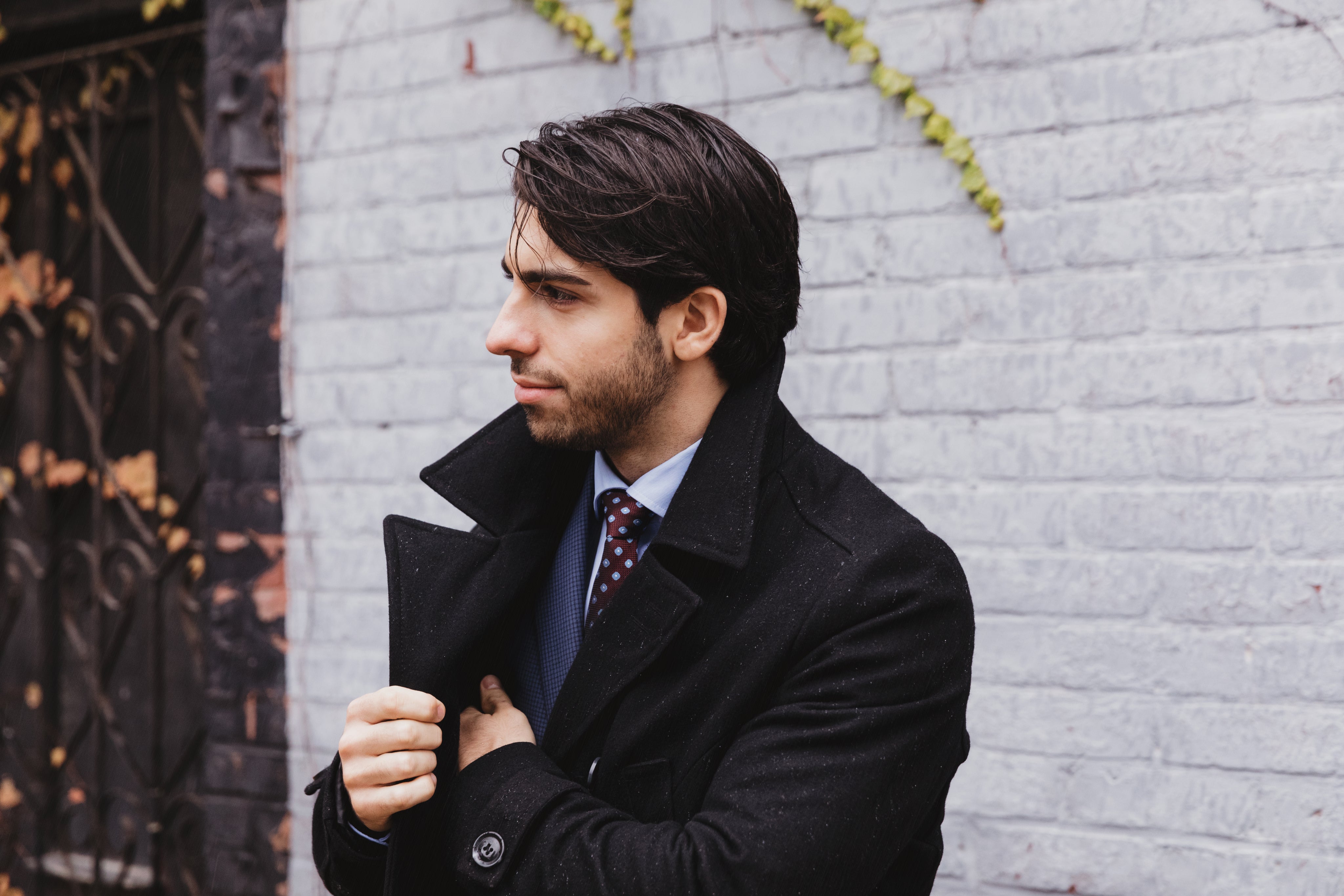 Stylish man wearing a camel overcoat with black turtleneck and tan pants